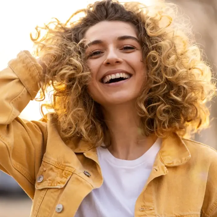 girl with curly hair with a bright smile