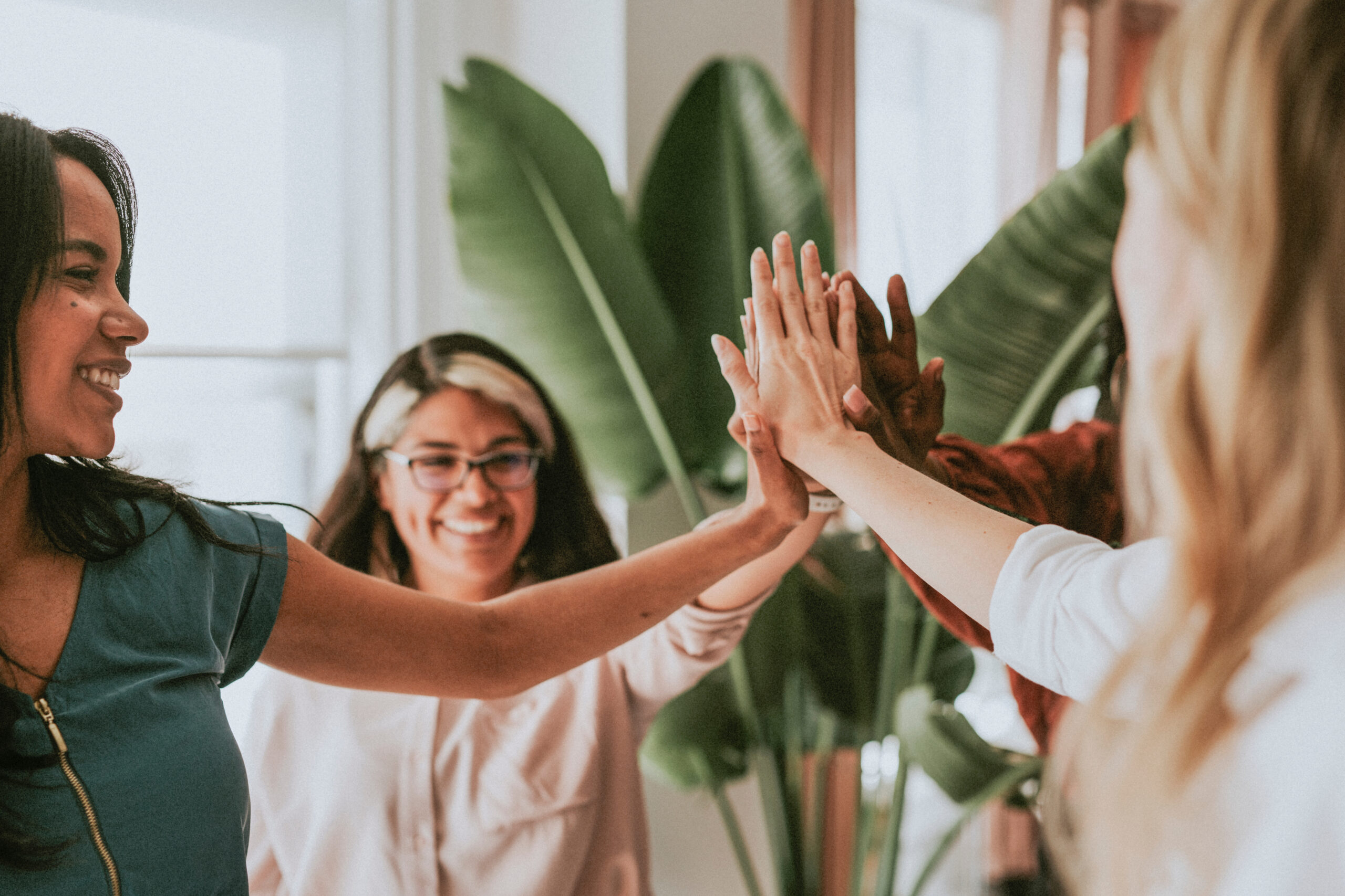 Businesswomen putting hands in the middle