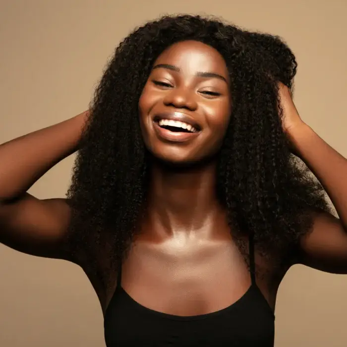 young woman smiling and holding her hair