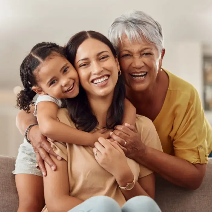 Grandma, mother, and daughter smiling