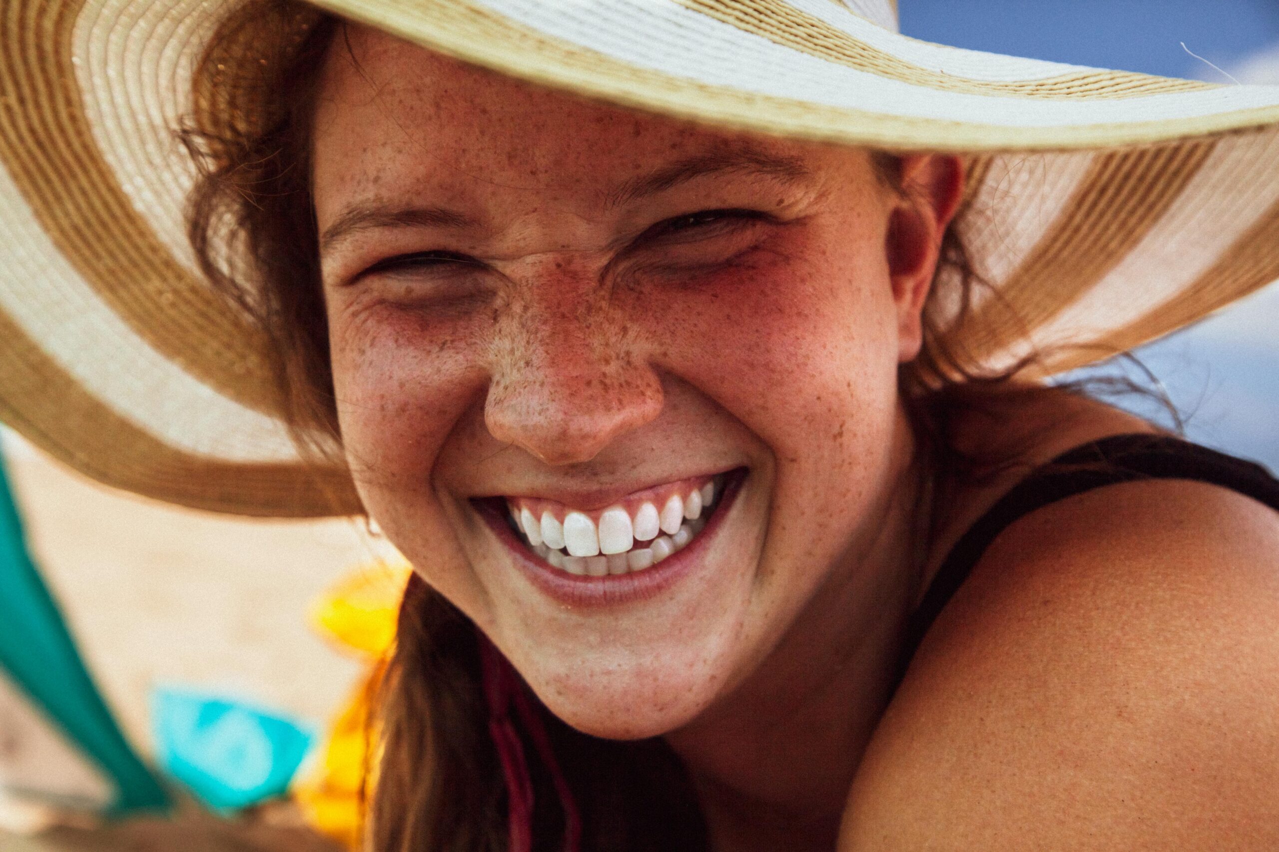 woman smiling at the beach after visiting a cosmetic dentist in Tigard for teeth whitening